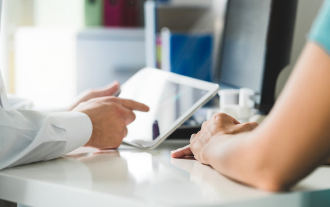 Patient and a dentist revising electronic health records.