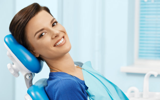Relaxed happy woman in a dental chair showing beautiful teeth in her smile.